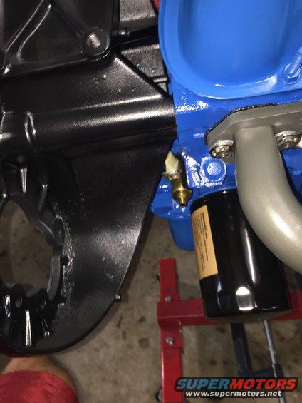 Close-up of engine block, oil filter, and exhaust manifold