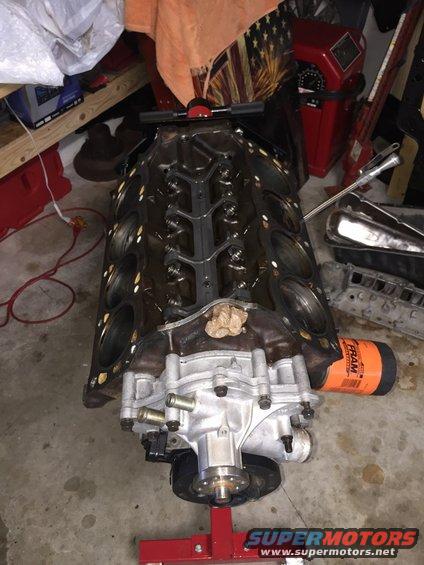 engine block with water pump and oil filter attached, on a red engine stand