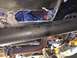 1989 Ford Bronco - Hole cut into the frame rail of a vehicle's underbody, with exhaust pipe visible.