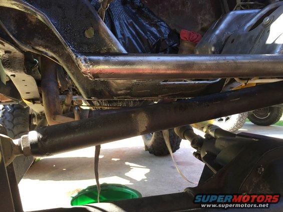 Undercarriage of a vehicle with visible suspension components and exhaust pipes