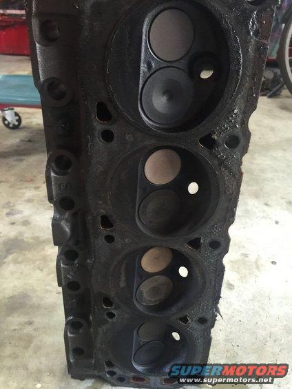 Close-up of a dirty engine cylinder head with multiple valves visible
