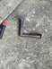 1989 Ford Bronco - A custom-fabricated metal bracket, likely for automotive modification, is shown on a concrete surface next to welding leads.