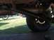 1989 Ford Bronco - Close-up of a vehicle's driveshaft and differential, with another vehicle in the background.