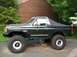 1989 Ford Bronco - This modified Ford Bronco features a soft top and oversized tires, giving it a appearance.