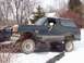 1989 Ford Bronco - A lifted 1989 Ford Bronco sits in a snowy driveway during winter.