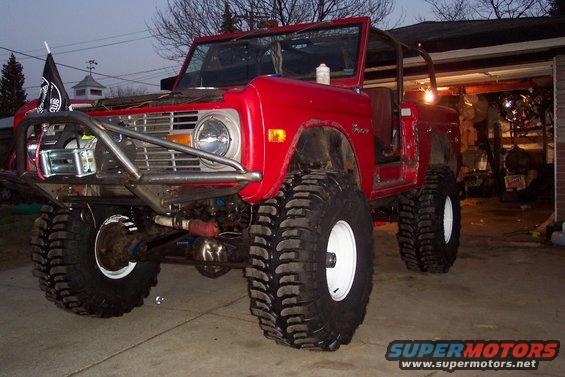 Red 1974 Ford Bronco with off-road tires and winch