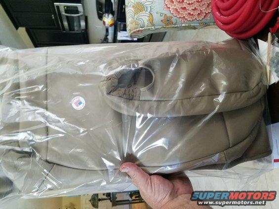 Tan seat covers in plastic packaging, with a small circular sticker that says 'Made in USA'