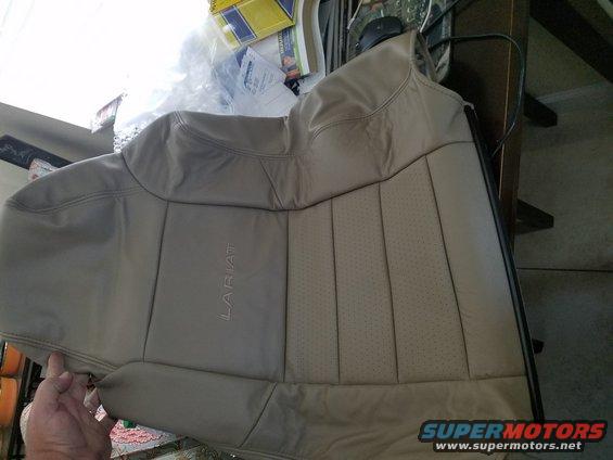 Tan leather car seat with "LARIAT" embossed on the side panel, showing perforated inserts