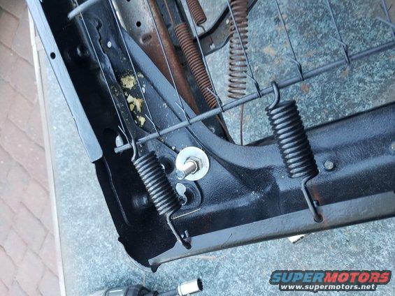 Close-up of seat springs and black metal frame with visible rust and yellow foam padding. Supermotors.net logo at bottom right