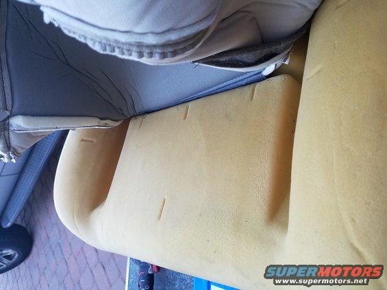 Close-up of yellow foam and grey fabric from a car seat cushion
