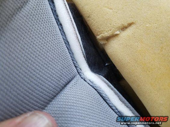 Close-up of torn seat foam and gray upholstery