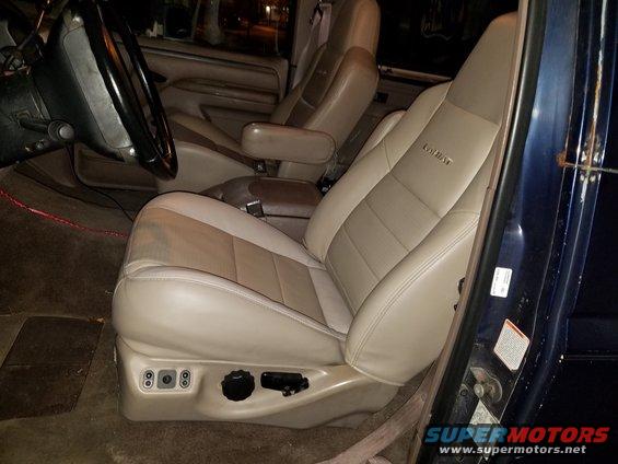 Tan and beige leather car seats with power controls visible on the driver's seat base