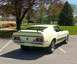 1971 Ford Mustang - Rear view of a yellow 1971 Ford Mustang Mach 1 with a spoiler and racing stripes.
