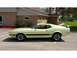 1971 Ford Mustang - This 1971 Ford Mustang Mach 1 features a distinctive side stripe and rear spoiler, presented in a pale yellow finish.