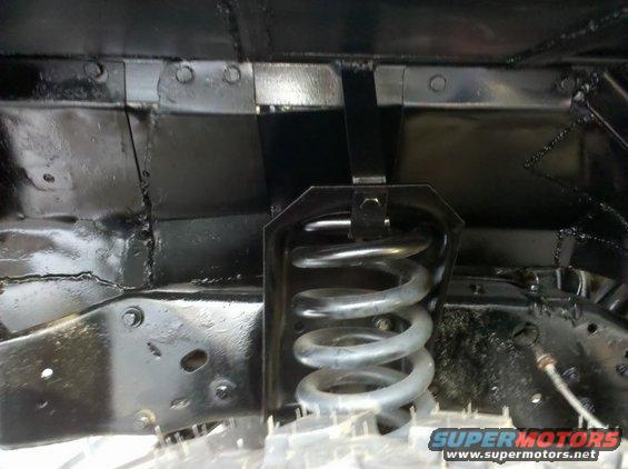 close-up of a vehicle's front suspension coil spring and frame