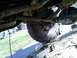 1989 Ford Bronco - The underside of a vehicle is shown, with a tire and suspension components visible.