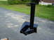 1989 Ford Bronco - A black trailer hitch assembly is shown on an asphalt surface with grass and a building in the background.