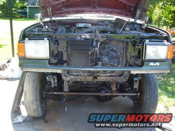 Green 1987 Ford Bronco front end with hood open, showing engine and radiator; 4x4 badge visible