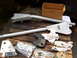 1989 Ford Bronco - Several suspension parts and a box of hardware are arranged on a wooden pallet.