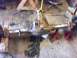 1989 Ford Bronco - A rusty differential axle assembly is supported by red jack stands in a workshop.