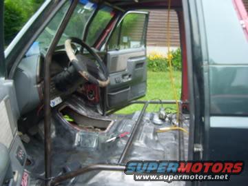 Vehicle interior with roll cage, removed seats, and exposed floor