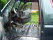 1989 Ford Bronco - The interior of a vehicle is shown with a prominent roll cage and stripped-down appearance.
