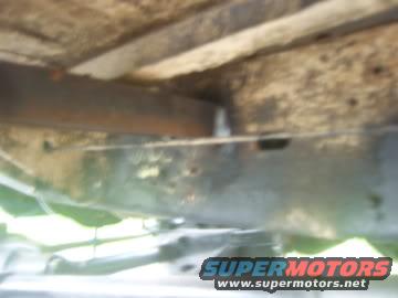 view of vehicle undercarriage with some rust and dirt