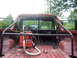 1989 Ford Bronco - Interior view of a red pickup truck with a roll cage and a shop vac in the bed.
