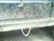 1989 Ford Bronco - A chain is attached to the lower body of a mud-covered vehicle.