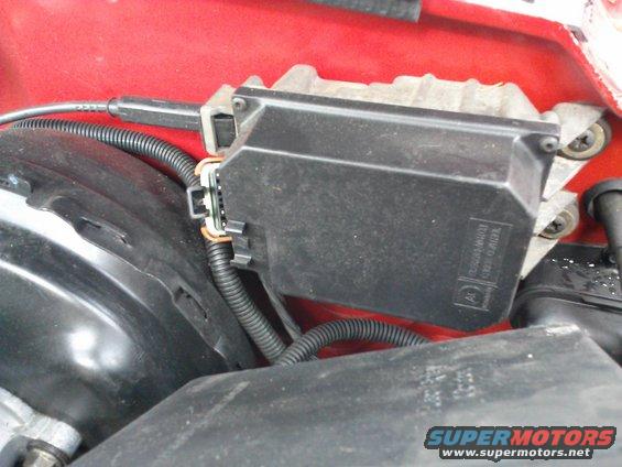 Close-up of a black plastic engine control module with wiring harness connected