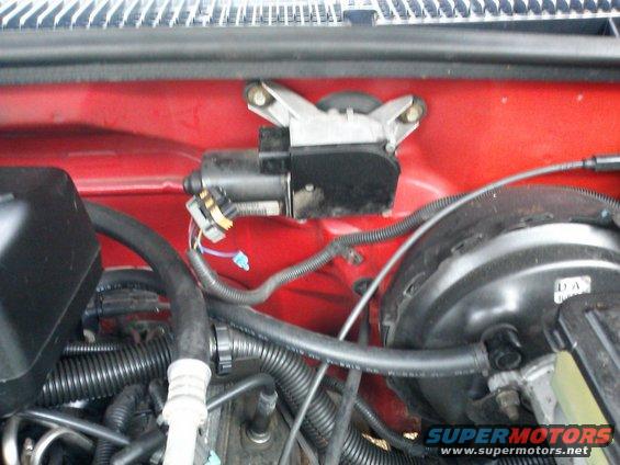 Red engine bay with windshield wiper motor and brake booster visible