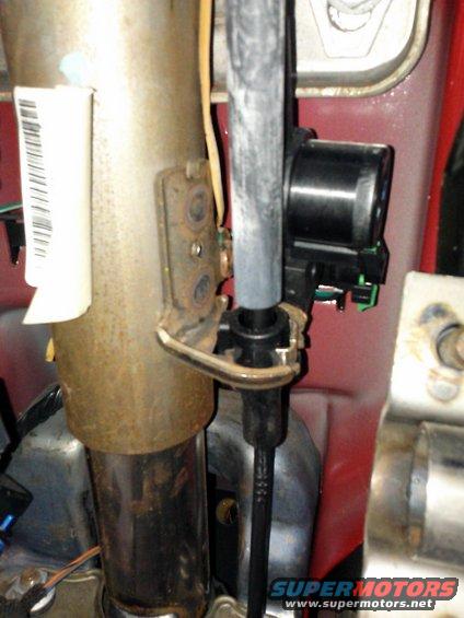 Close-up of steering column assembly with a black electrical connector attached