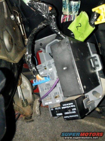 Close-up of vehicle interior wiring harness and fuse box with labels visible