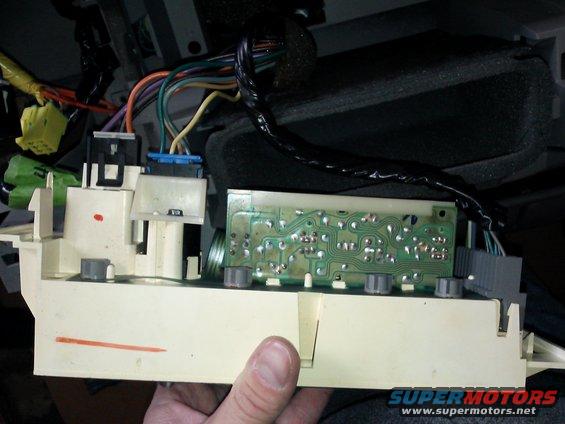 Close-up of a car's interior electrical control module with wires and circuit board
