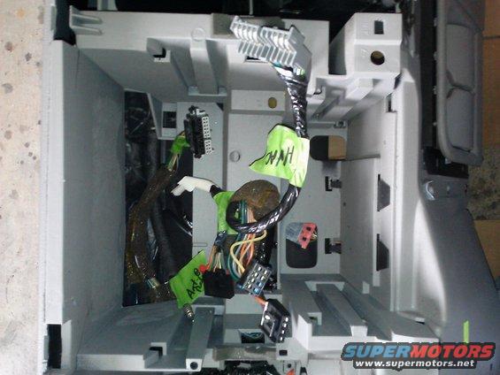 Vehicle wiring harness with green tape labels, one reading 'Art-B', connected to a gray plastic bracket