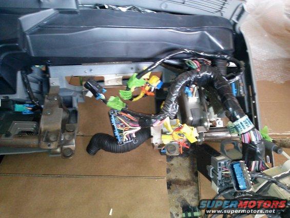 Vehicle wiring harness with many colorful wires and connectors, some taped up