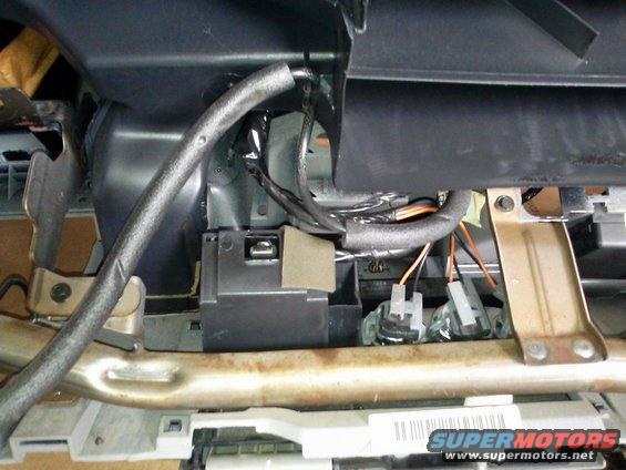 Dashboard wiring and components with a prominent gray hose