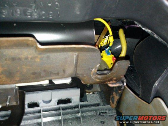 Dashboard wiring harness with yellow and blue connectors and a yellow cable with a caution label