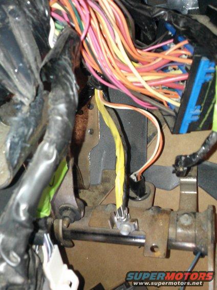 Close-up of a tangled vehicle wiring harness with many colored wires and connectors