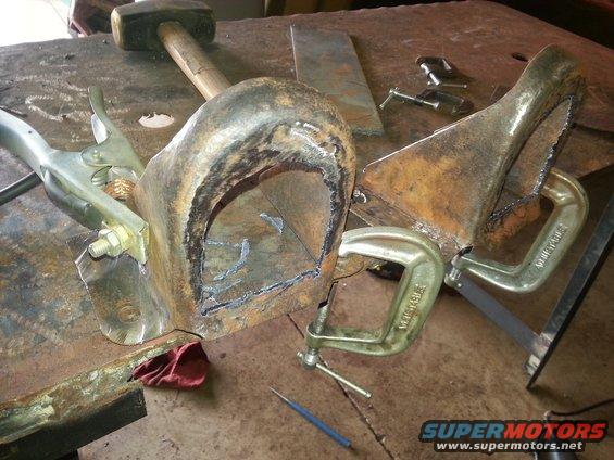 Welding part clamped to workbench with a sledgehammer nearby