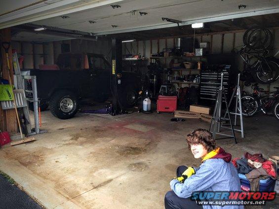 Garage interior with some equipment and a person sitting