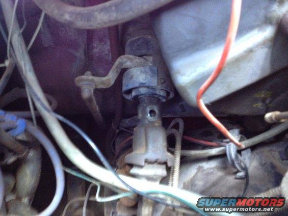 Close-up of vehicle steering column linkage with wires and hoses