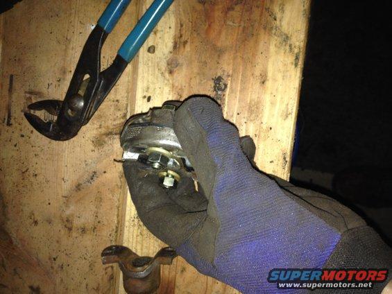 Part being worked on with pliers and gloved hand