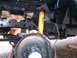 1978 Ford F-250 - Close-up of a vehicle's front suspension, showing a yellow Monroe shock absorber and brake components during a rebuild.