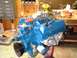 1978 Ford F-250 - A freshly painted blue V8 engine sits on a stand in a workshop, ready for installation.