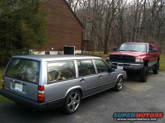 1991 Volvo 940 wagon parked next to a red pickup truck