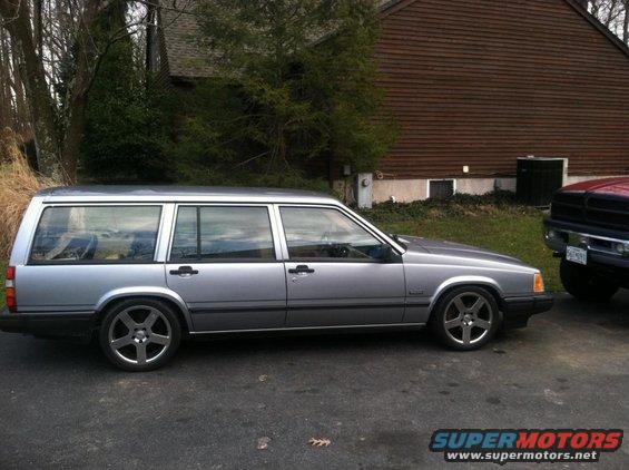 Silver 1991 Volvo 940 station wagon parked next to a red truck