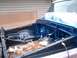 1978 Ford F-250 - The engine bay of a truck is being prepped for work, with blue paint applied to the frame and inner fenders.