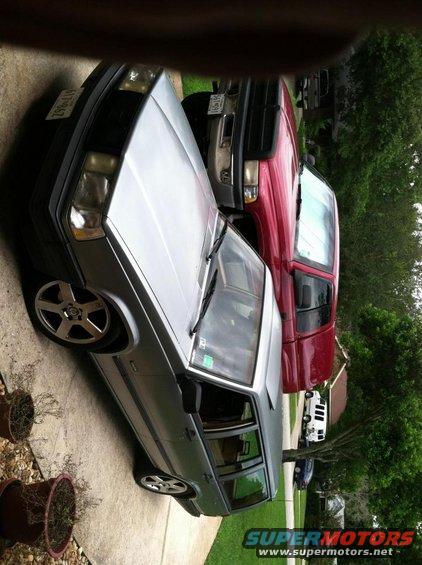 1991 Volvo 940 station wagon parked next to a red pickup truck