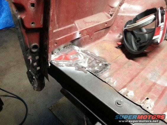 Red vehicle interior floor with rust repair and a welding mask